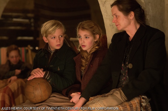 Liesel (Sophie Nélisse, center), her friend Rudy (Nico Liersch), and her foster mother Rosa (Emily Watson) await news in a bomb shelter in The Book Thief..