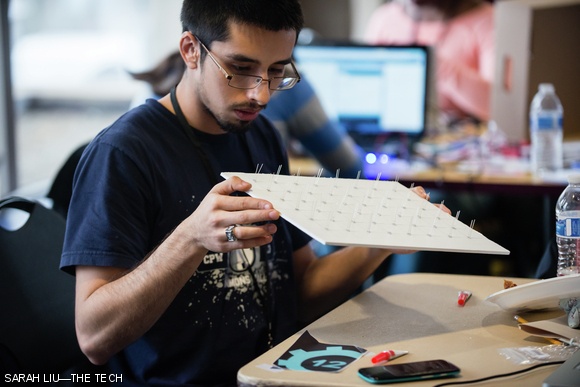 Edgardo Farias ‘15 inspects a board of LEDs, which he plans to make into a physical game of Flappy Bird.
