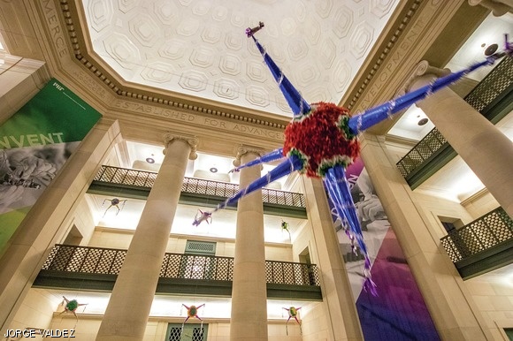 Swinging piñatas fly around Lobby 7 early Wednesday morning. The hack, organized by MITMex, was made to share the Mexican tradition of breaking star-shaped piñatas during Christmastime.