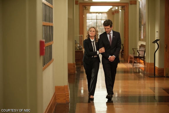 Leslie (Amy Poehler) and Ben (Adam Scott) walk down the main aisle of the Parks department one last time in the show’s finale.